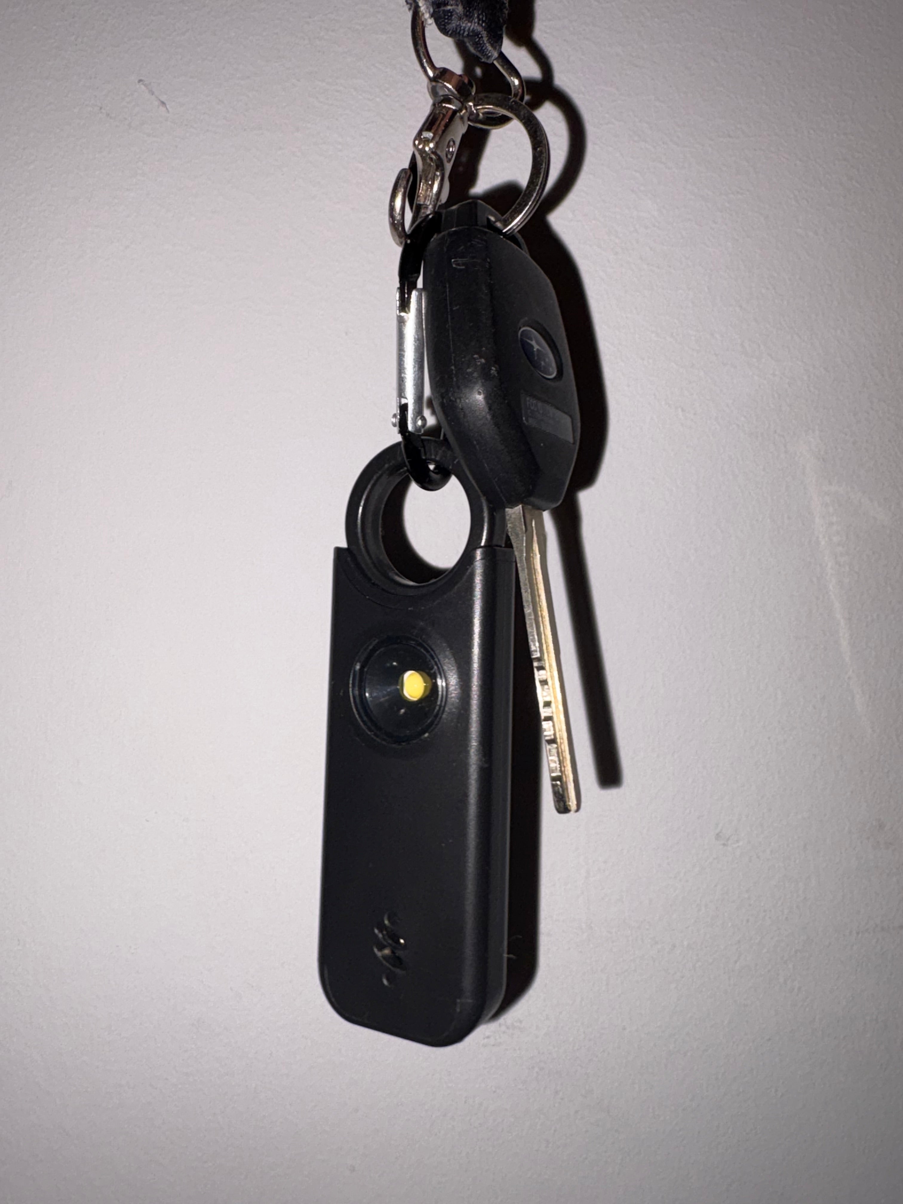 The black AlertaSafe alarm attached to a set of car keys